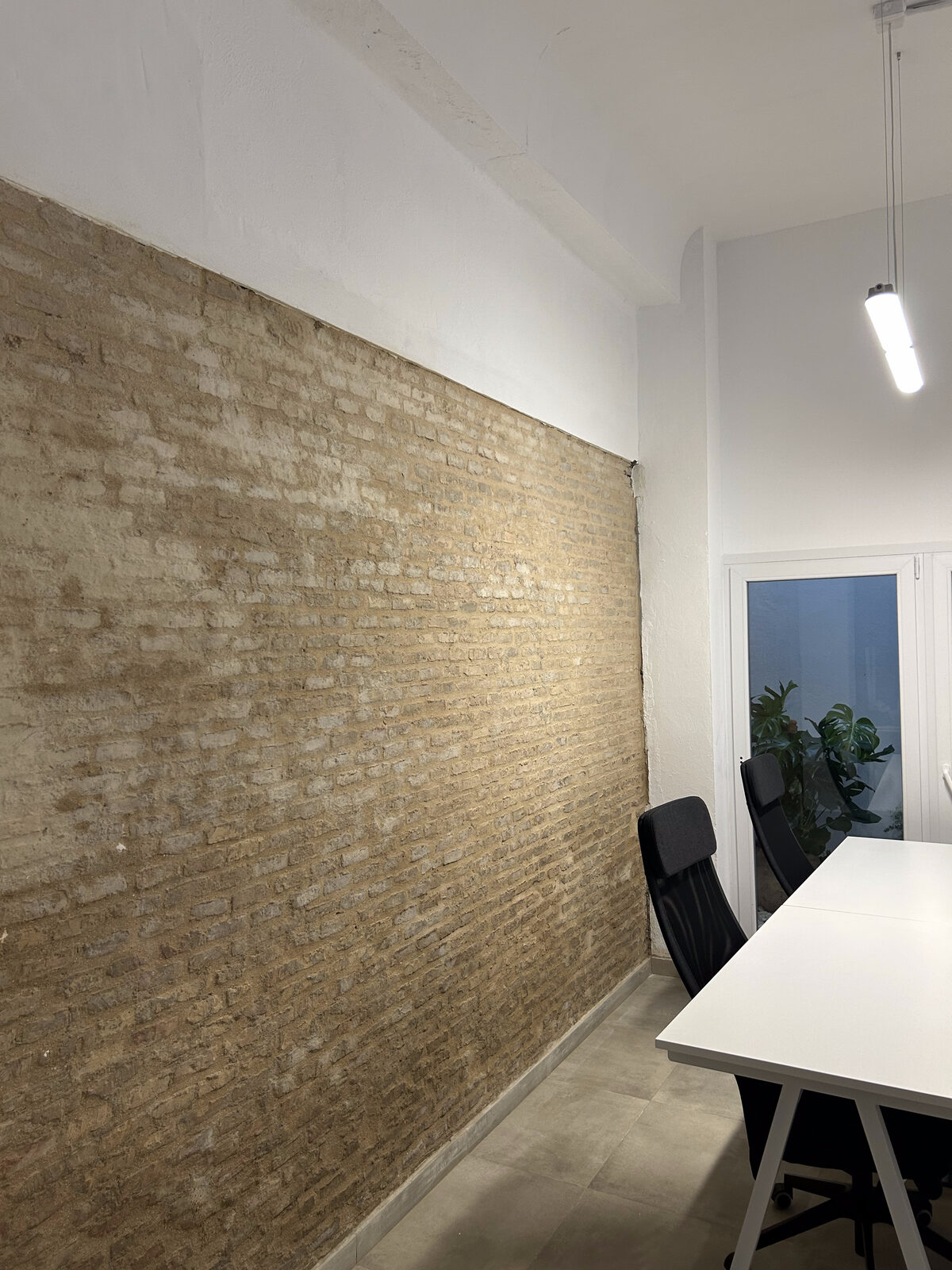 Pared de ladrillo visto y mesa de reuniones